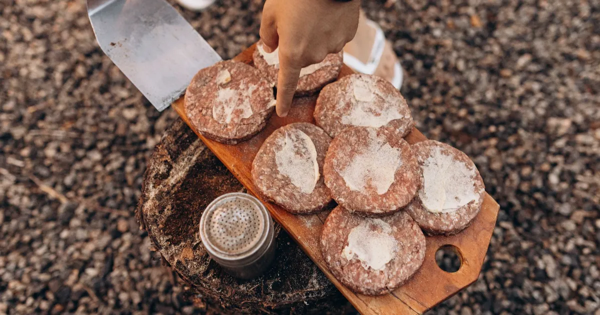 Raw ground beef patties on a cutting board